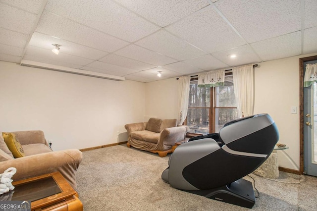 living room with a paneled ceiling, baseboards, and carpet