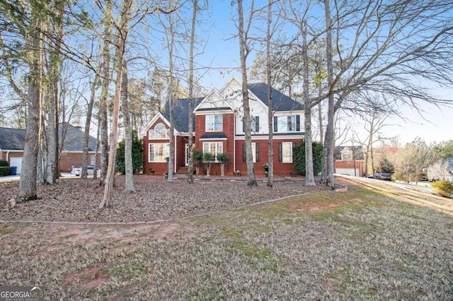 view of front of home featuring a front yard, brick siding, and a garage