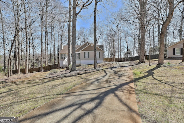 view of front facade with a chimney and fence