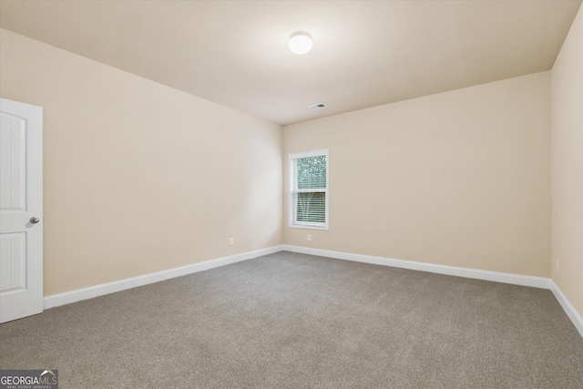 spare room with visible vents, baseboards, and carpet