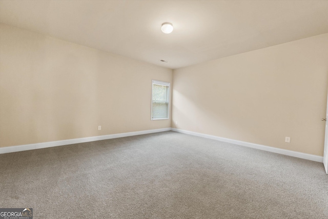 carpeted empty room featuring baseboards