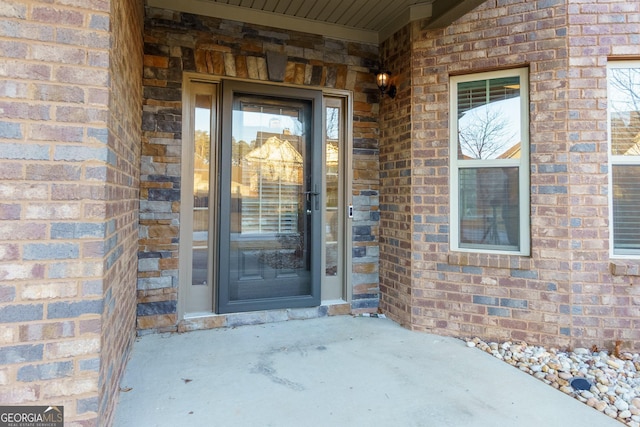 view of exterior entry featuring brick siding