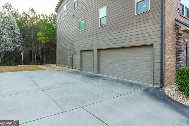 view of side of property featuring a garage and driveway