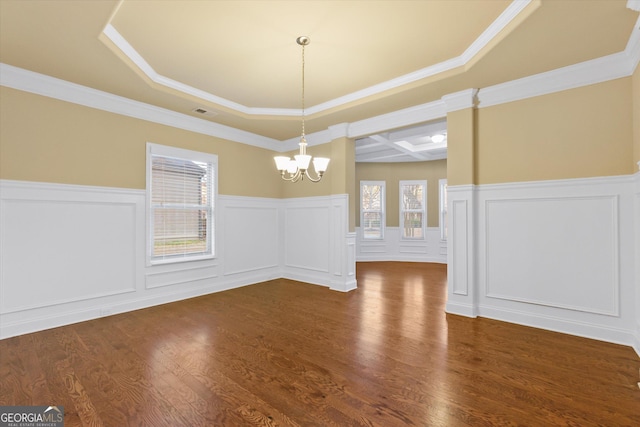 unfurnished dining area featuring a wainscoted wall, visible vents, a notable chandelier, dark wood-style floors, and a decorative wall