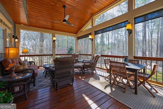 sunroom / solarium featuring a ceiling fan, lofted ceiling, and wood ceiling