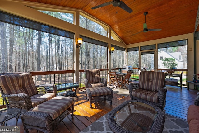 sunroom / solarium with lofted ceiling, wooden ceiling, and ceiling fan