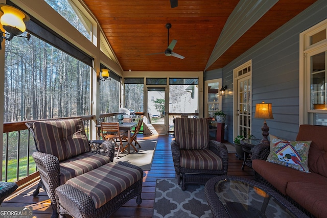 sunroom featuring a ceiling fan, lofted ceiling, a healthy amount of sunlight, and wooden ceiling