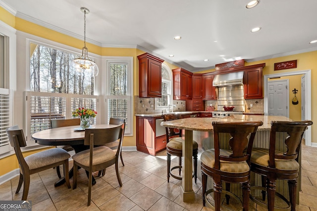 kitchen featuring ornamental molding, a kitchen island, tasteful backsplash, wall chimney exhaust hood, and dark brown cabinets