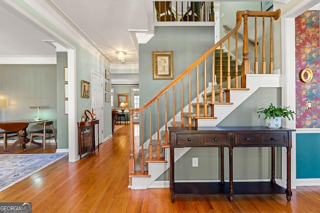 staircase with baseboards, wood finished floors, and ornamental molding