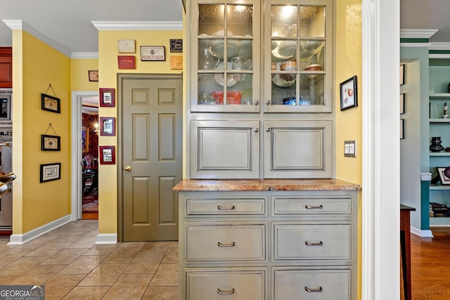 details featuring stainless steel microwave, baseboards, and crown molding