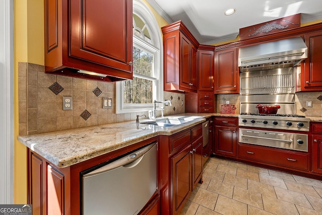 kitchen featuring light stone countertops, stainless steel appliances, decorative backsplash, wall chimney exhaust hood, and reddish brown cabinets