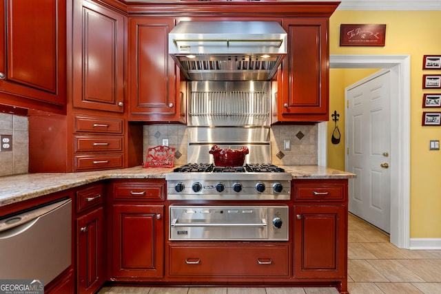 kitchen featuring light stone counters, dark brown cabinets, appliances with stainless steel finishes, wall chimney exhaust hood, and tasteful backsplash