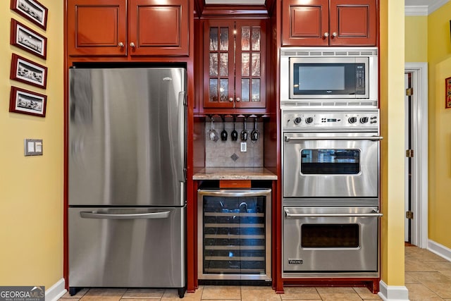 kitchen with light tile patterned floors, beverage cooler, stainless steel appliances, glass insert cabinets, and tasteful backsplash