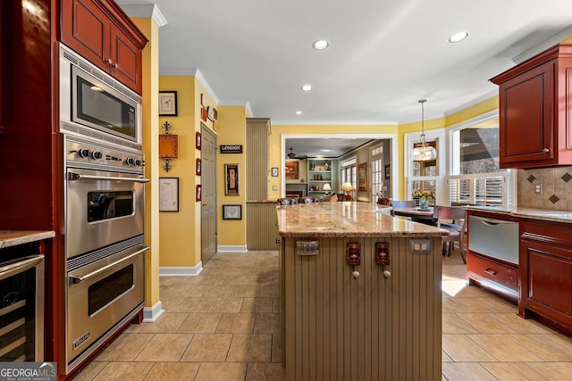 kitchen with beverage cooler, a center island, appliances with stainless steel finishes, crown molding, and dark brown cabinets