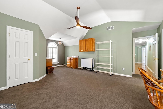 unfurnished living room featuring visible vents, baseboards, dark colored carpet, lofted ceiling, and ceiling fan