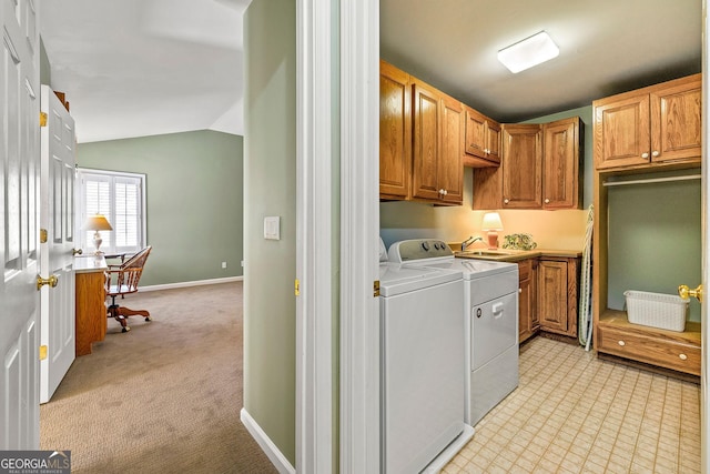 washroom featuring baseboards, cabinet space, a sink, light colored carpet, and independent washer and dryer