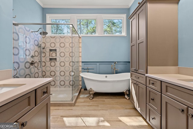 full bath featuring a stall shower, a wealth of natural light, ornamental molding, and vanity