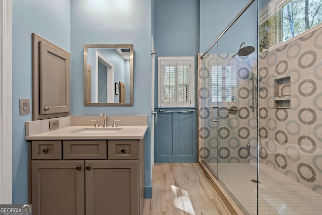 bathroom featuring vanity, wood finished floors, and a tile shower