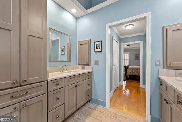 full bath with vanity, wood finished floors, baseboards, ensuite bath, and crown molding