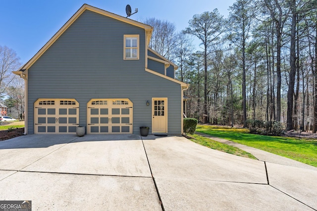 view of home's exterior with a lawn, concrete driveway, and an attached garage