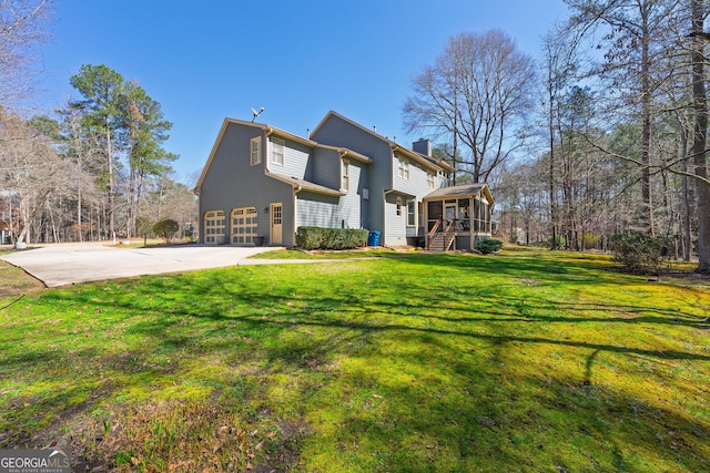 view of property exterior with a sunroom, a chimney, concrete driveway, a garage, and a lawn