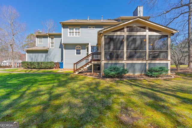 back of property featuring a lawn, a chimney, stairs, and a sunroom