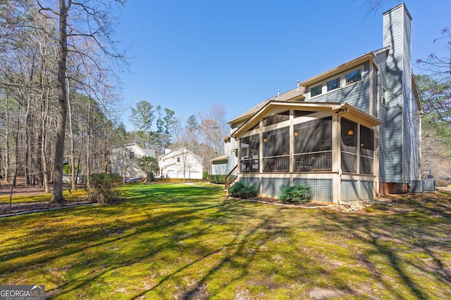 view of yard with central AC and a sunroom