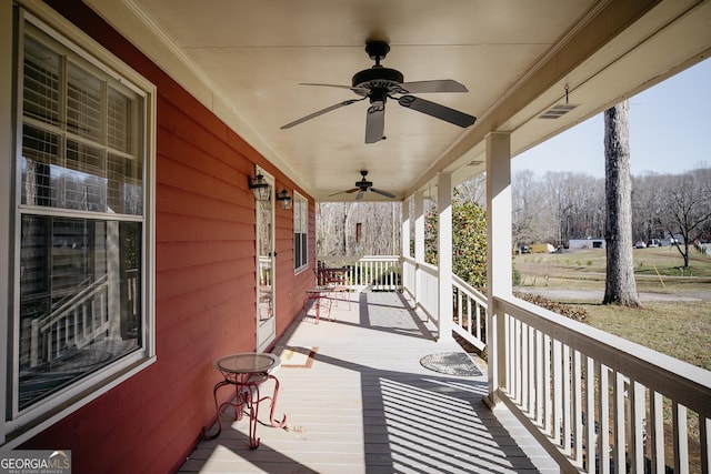 wooden terrace with covered porch and ceiling fan
