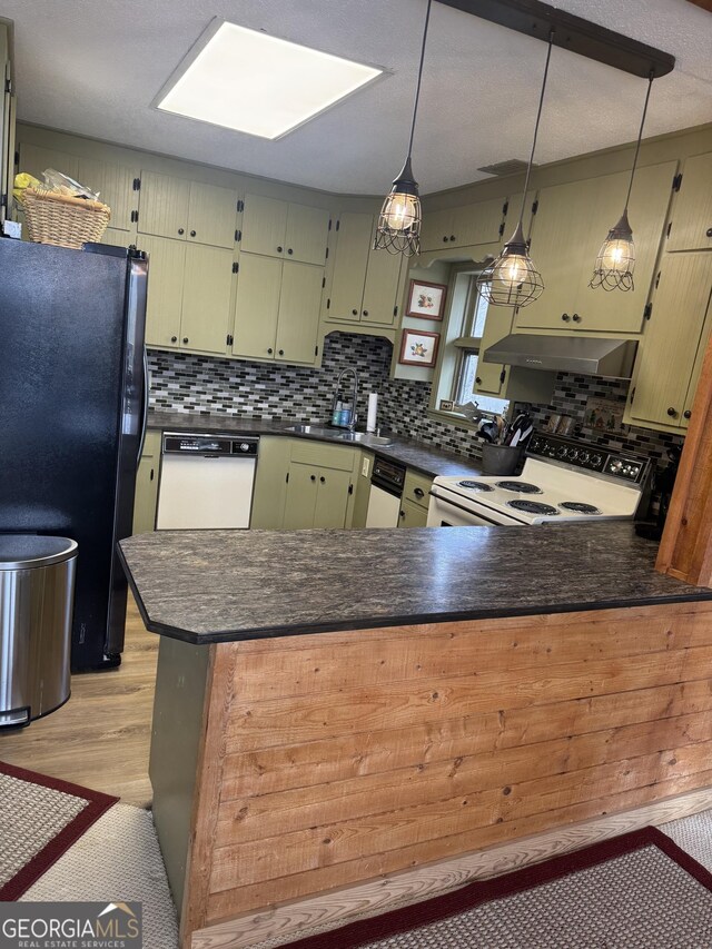 63 Mashie Ln, Sky Valley, GA 30537 - kitchen featuring white appliances, dark countertops, a peninsula, and backsplash
