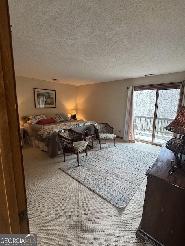 bedroom with access to outside, carpet, visible vents, and a textured ceiling