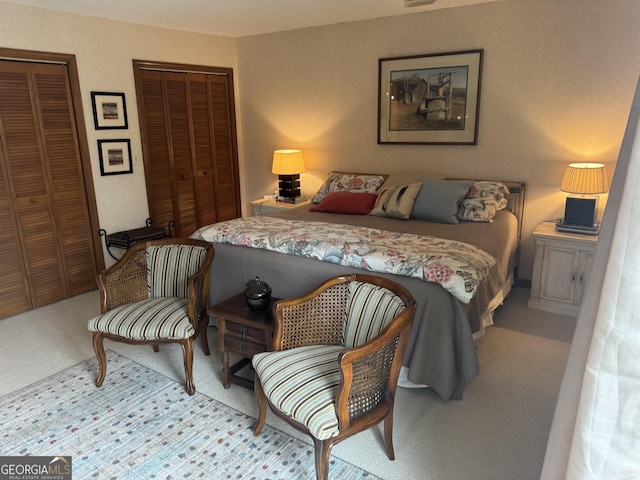 bedroom with carpet flooring and two closets