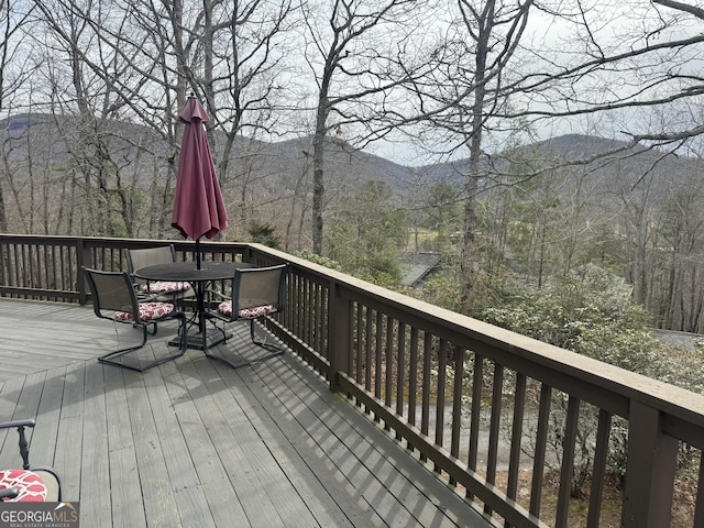 wooden terrace featuring outdoor dining area and a mountain view