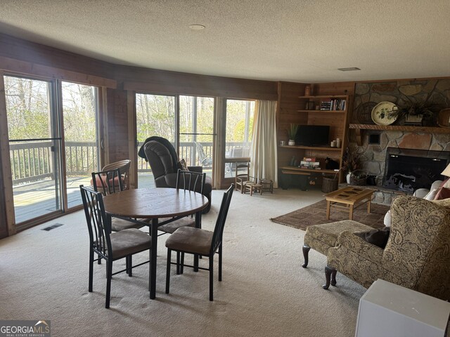 63 Mashie Ln, Sky Valley, GA 30537 - carpeted dining area with a textured ceiling, a fireplace, and wooden walls