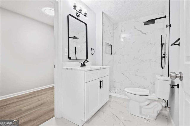 bathroom featuring vanity, a marble finish shower, a textured ceiling, toilet, and marble finish floor