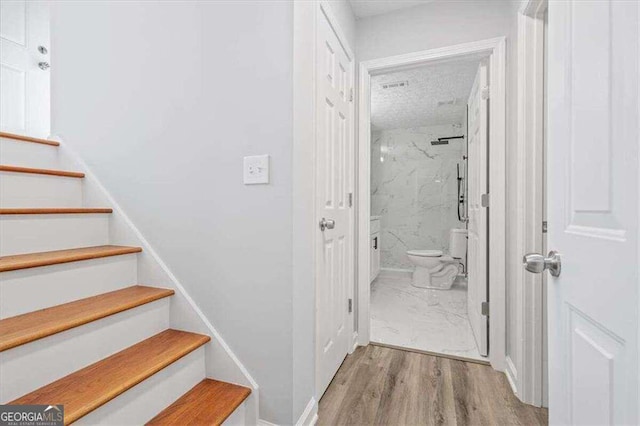 stairway with visible vents and wood finished floors