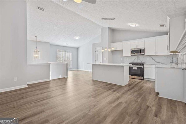 kitchen with visible vents, open floor plan, white cabinetry, stainless steel appliances, and dark wood-style flooring