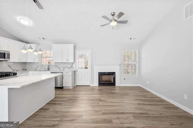 kitchen featuring vaulted ceiling, tasteful backsplash, visible vents, and appliances with stainless steel finishes