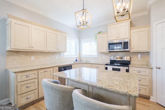 kitchen featuring crown molding, light wood finished floors, appliances with stainless steel finishes, and a sink