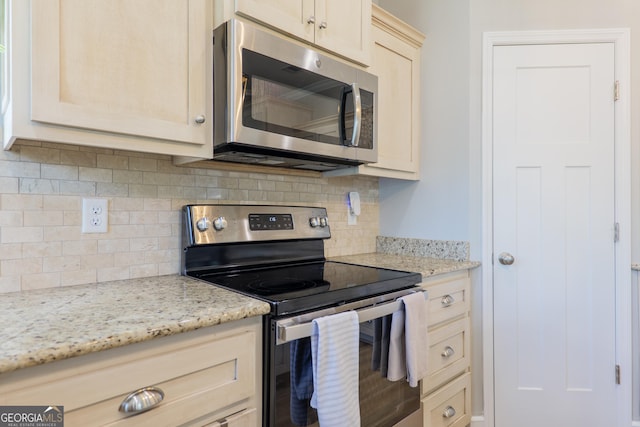 kitchen with stainless steel appliances, light stone countertops, and backsplash