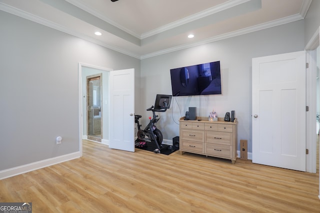 interior space featuring a tray ceiling, light wood-style flooring, and ornamental molding