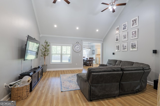 living area with baseboards, high vaulted ceiling, light wood-style flooring, ceiling fan, and crown molding