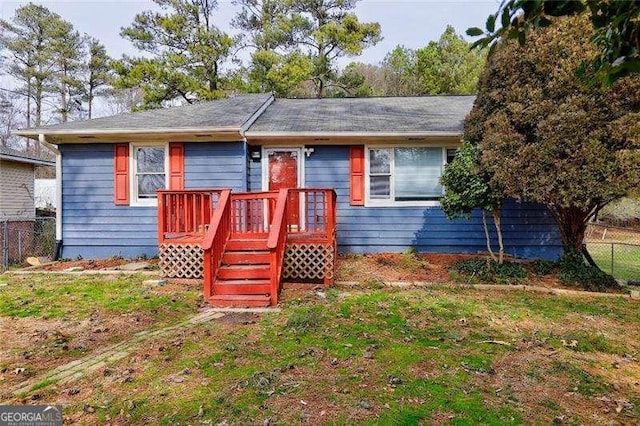 single story home with a front lawn and fence