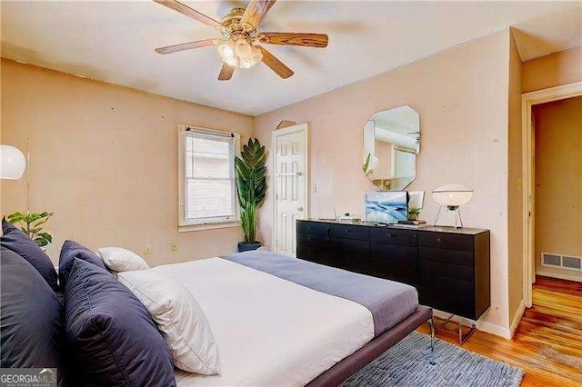 bedroom featuring visible vents, light wood-style flooring, baseboards, and ceiling fan