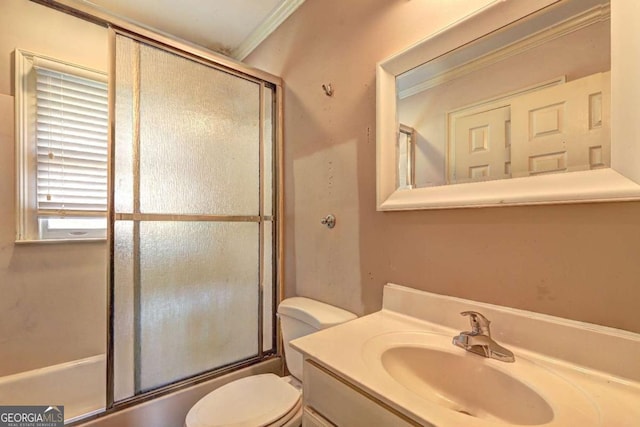 full bath with vanity, crown molding, toilet, and shower / bath combination with glass door