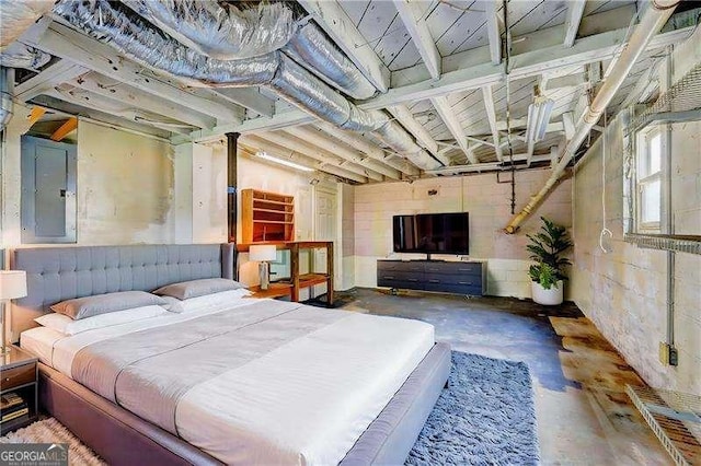 bedroom featuring electric panel and unfinished concrete flooring