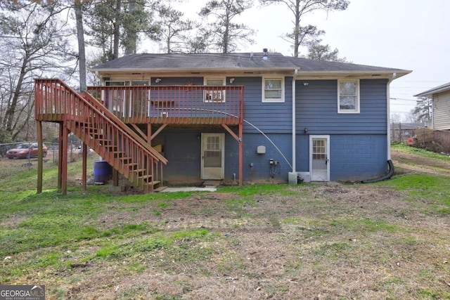 back of property with a deck, stairway, and a yard