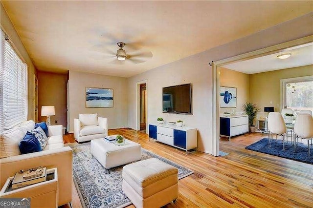 living room featuring light wood-type flooring and ceiling fan