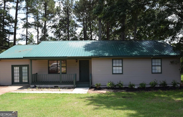 view of front of home with french doors, covered porch, a front yard, and metal roof