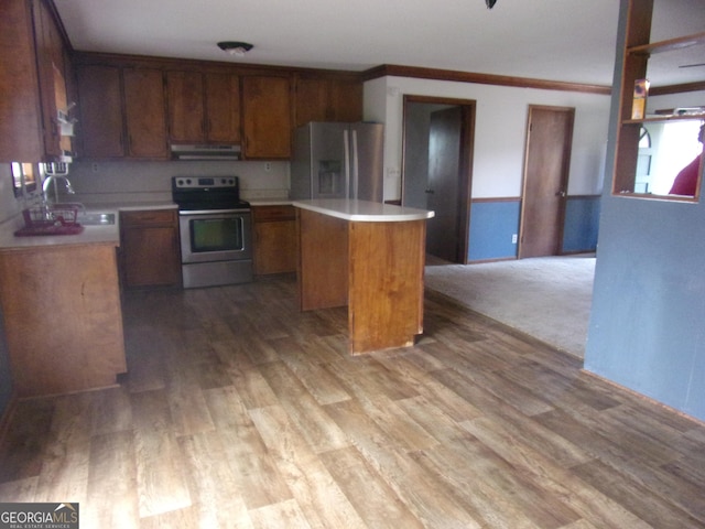 kitchen featuring under cabinet range hood, a center island, stainless steel appliances, and light countertops