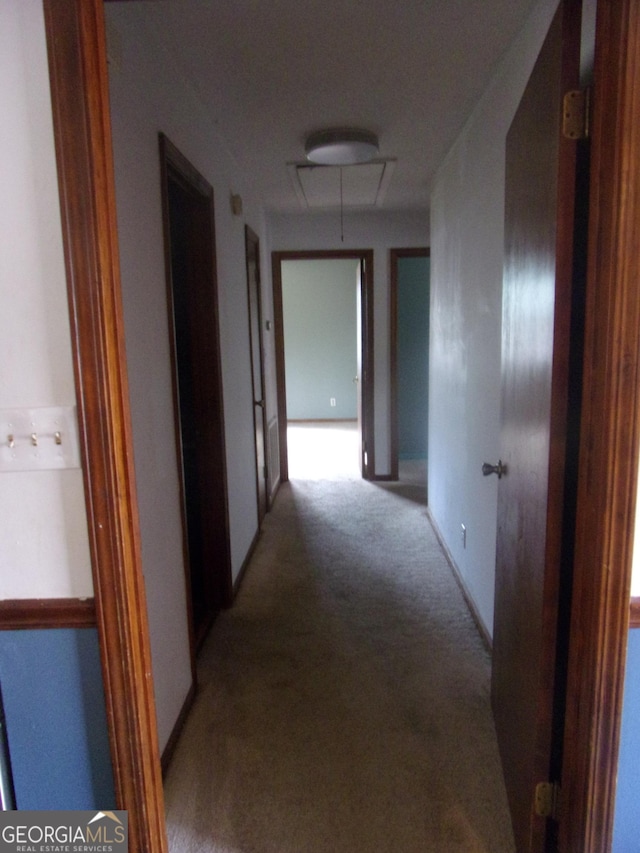 hallway featuring light carpet and attic access